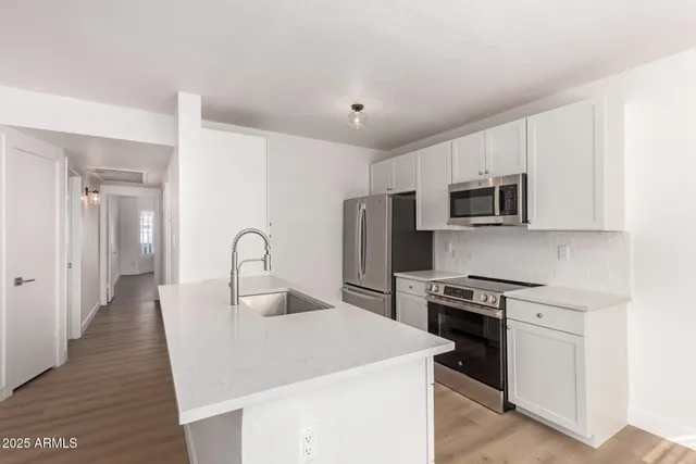 a kitchen with stainless steel appliances a sink stove and refrigerator