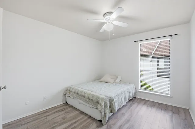 a bedroom with a bed and a chandelier fan