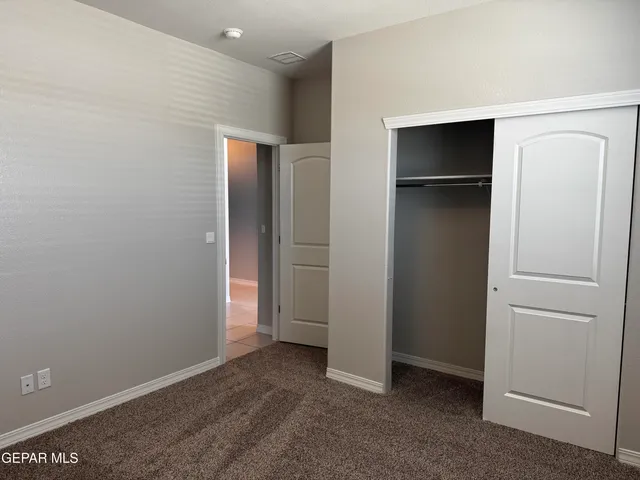 a view of an empty room with closet and wooden floor