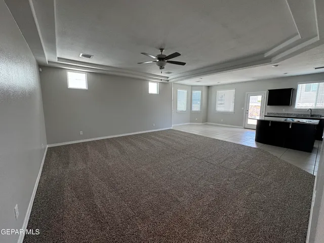 an empty room with windows and ceiling fan