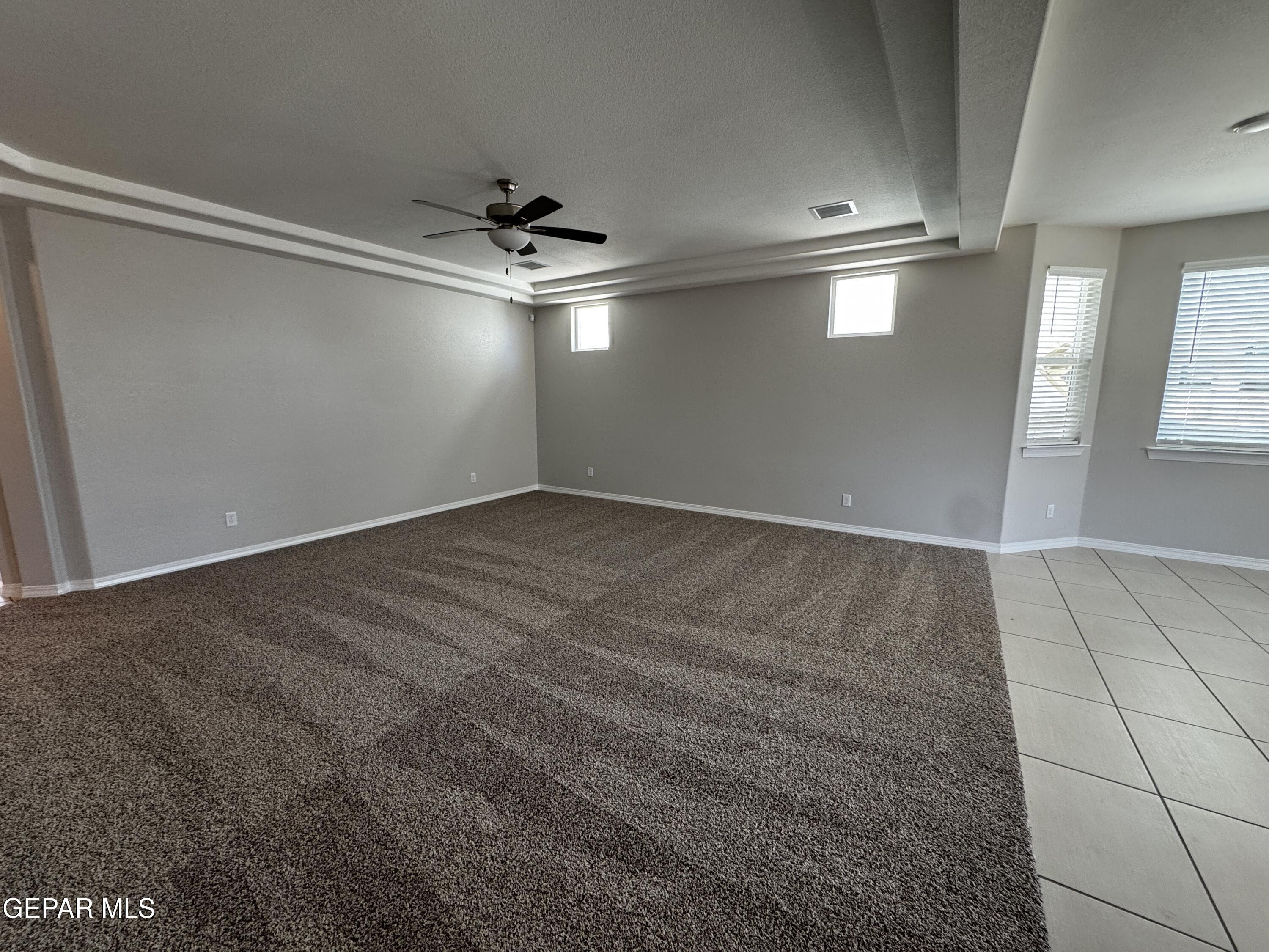 14434 Aria Lopez Drive El Paso, TX 79938 - Photo 22 of 37 an empty room with kitchen view and windows