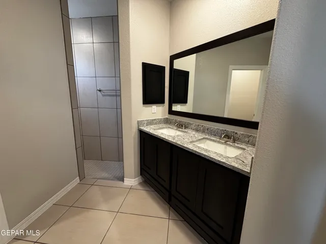 a bathroom with a granite countertop sink and a mirror