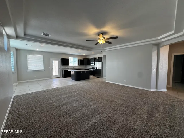 a view of empty room with a kitchen