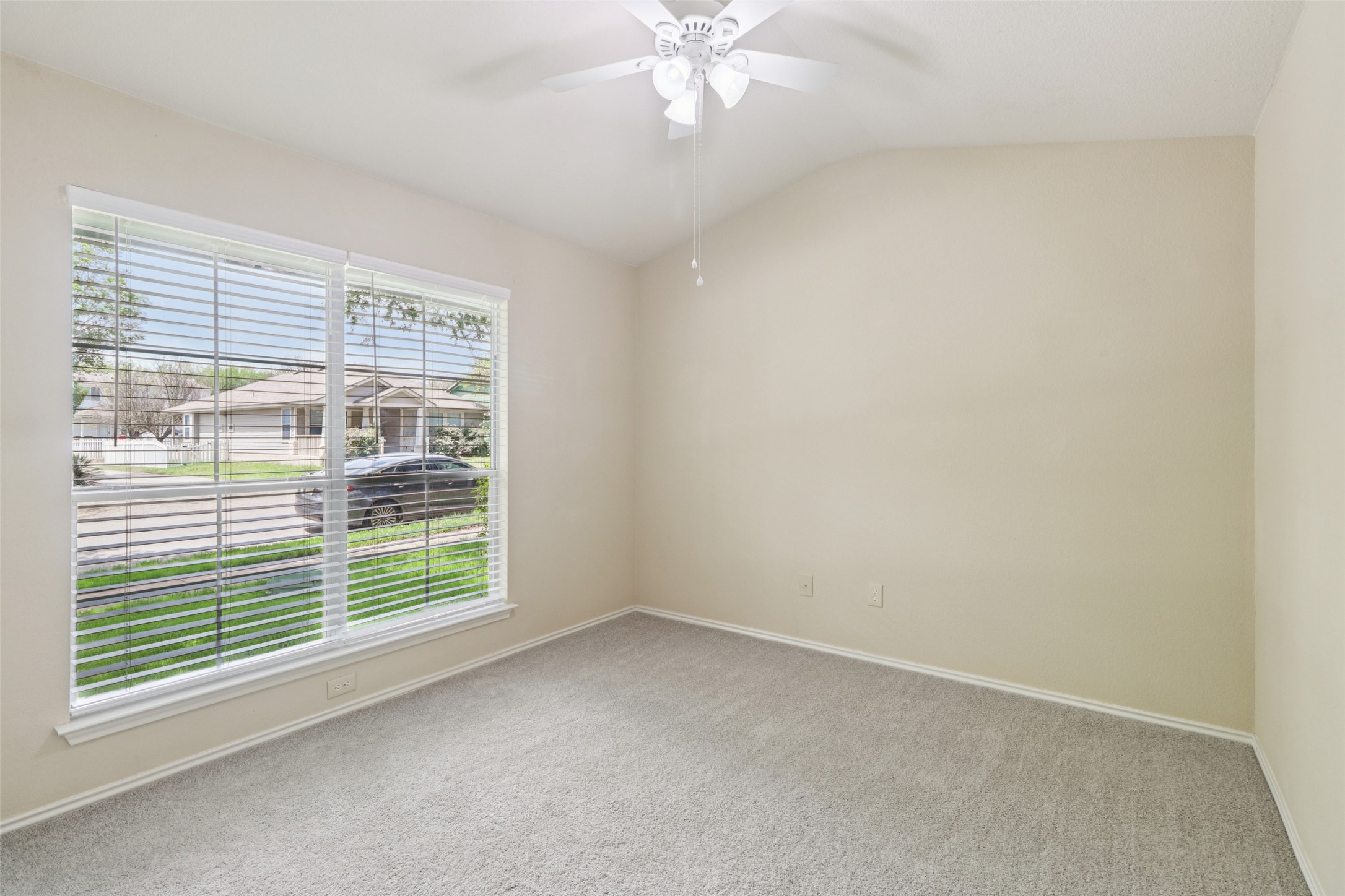 700 Scheel Road Kyle, TX 78640 - Photo 28 of 39 The property features a room with vaulted ceilings, a ceiling fan, and light-colored carpet