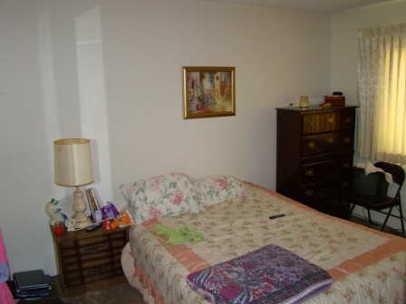 12221 Sandstone Drive Redding, CA 96003 - Photo 27 of 33 a bed sitting in a bedroom next to a window with dresser and couch