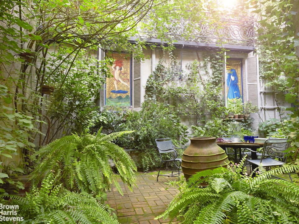 203 Prince Street Manhattan, NY 10012 - Photo 22 of 45 a backyard of a house with outdoor seating and plants