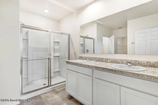 a bathroom with a shower sink and mirror