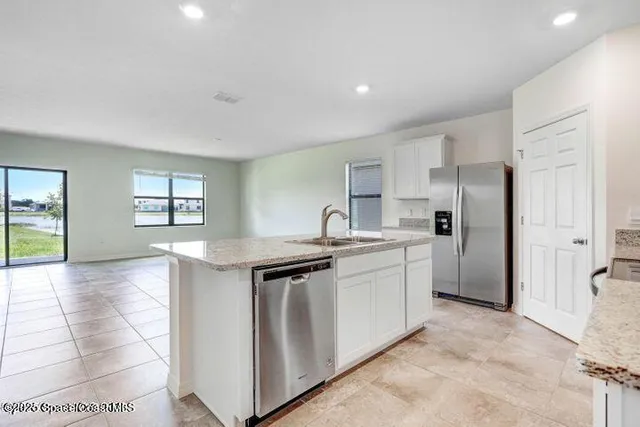 a kitchen with stainless steel appliances granite countertop a refrigerator and a sink
