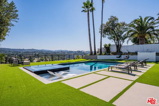a view of swimming pool with chairs and a table