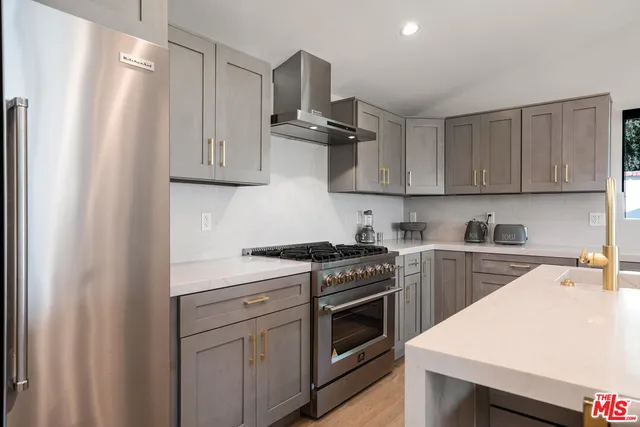 a kitchen with stainless steel appliances a stove a sink and white cabinets