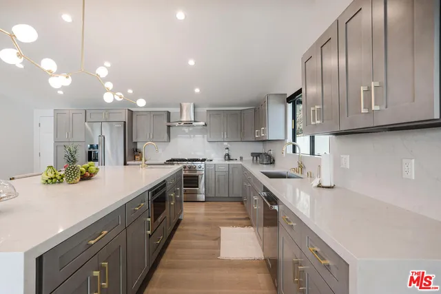 a kitchen with kitchen island granite countertop a sink a counter top space stainless steel appliances and cabinets