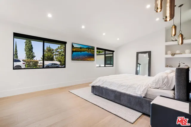 a spacious bedroom with a large bed and a window