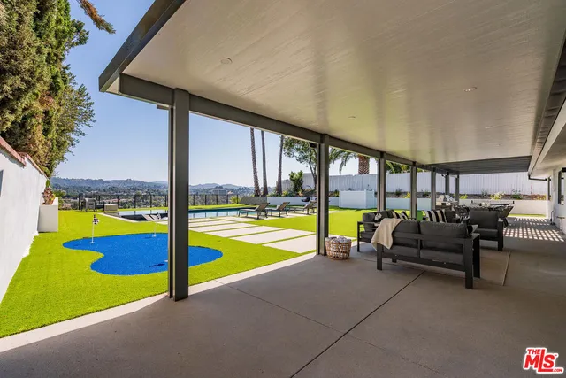 a living room with furniture and floor to ceiling window