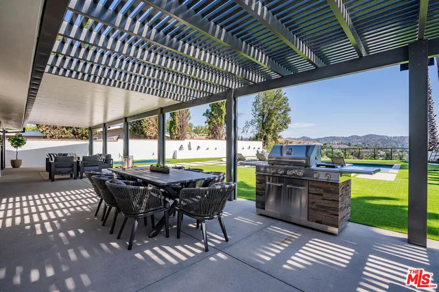 a view of a patio with a table and chairs under an umbrella