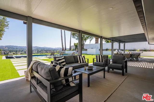 a living room with furniture and floor to ceiling windows