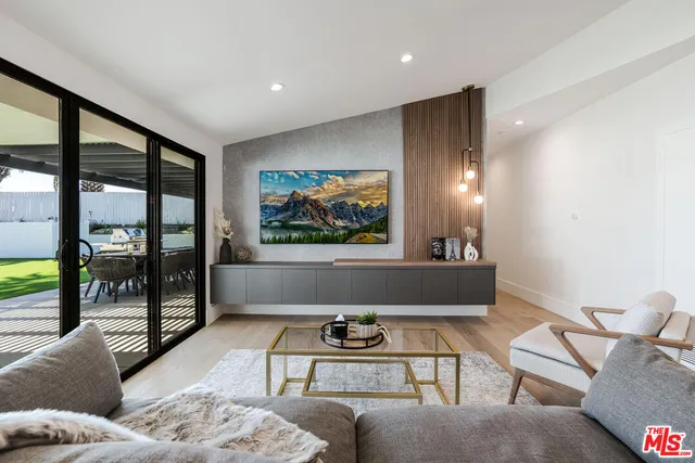 a living room with furniture and a floor to ceiling window