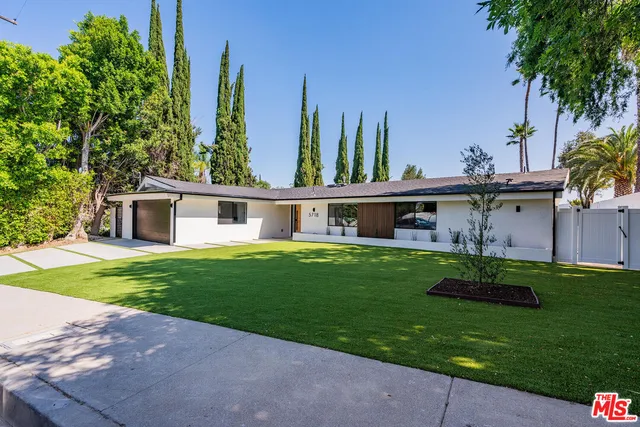 a view of a house with a yard and a garden