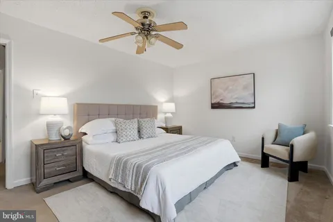 a bedroom with a bed a couch and a chandelier