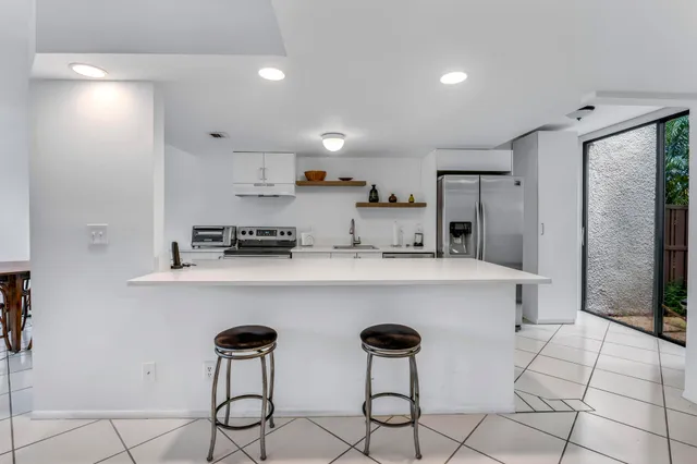 a kitchen with granite countertop a sink stainless steel appliances and cabinets