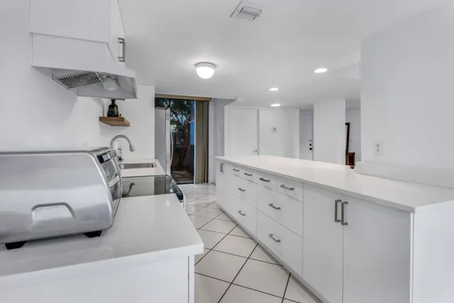a view of a hallway with wooden floor and a bathroom