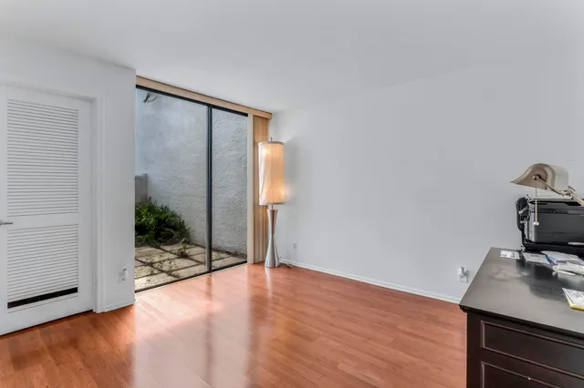 a living room with lots of furniture a rug and a large window