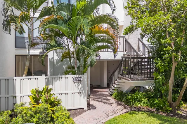 an aerial view of a residential houses with outdoor space and trees all around