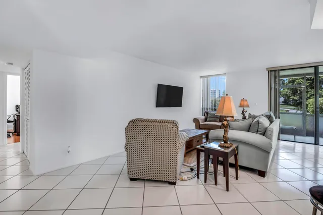 a dining room with furniture and large windows