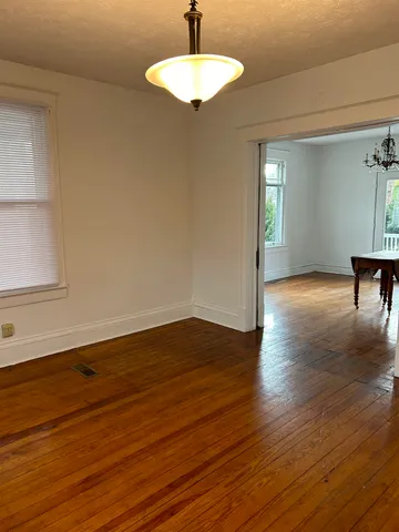a view of a room with wooden floor table and chair