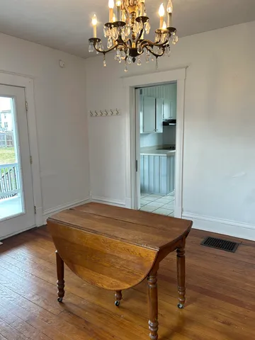 a room with a table chairs and wooden floor