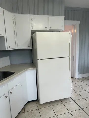 a view of a kitchen with a refrigerator and a more cabinets
