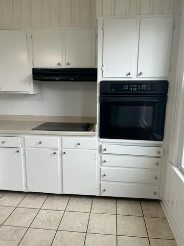 a kitchen with white cabinets and appliances