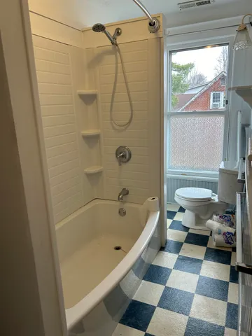 a bathroom with a bathtub and a toilet