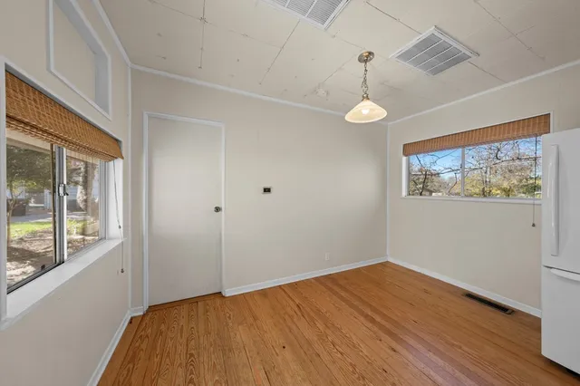 a view of empty room with wooden floor and window