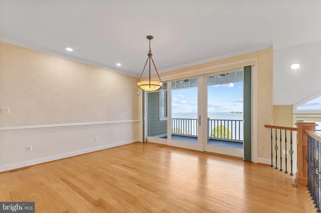 a kitchen with stainless steel appliances granite countertop a refrigerator a sink dishwasher a stove and a microwave oven on the wooden floor