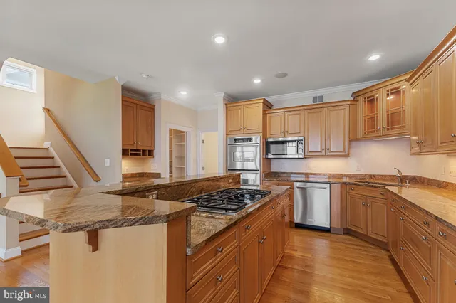 a kitchen with stainless steel appliances granite countertop a stove a sink and a refrigerator