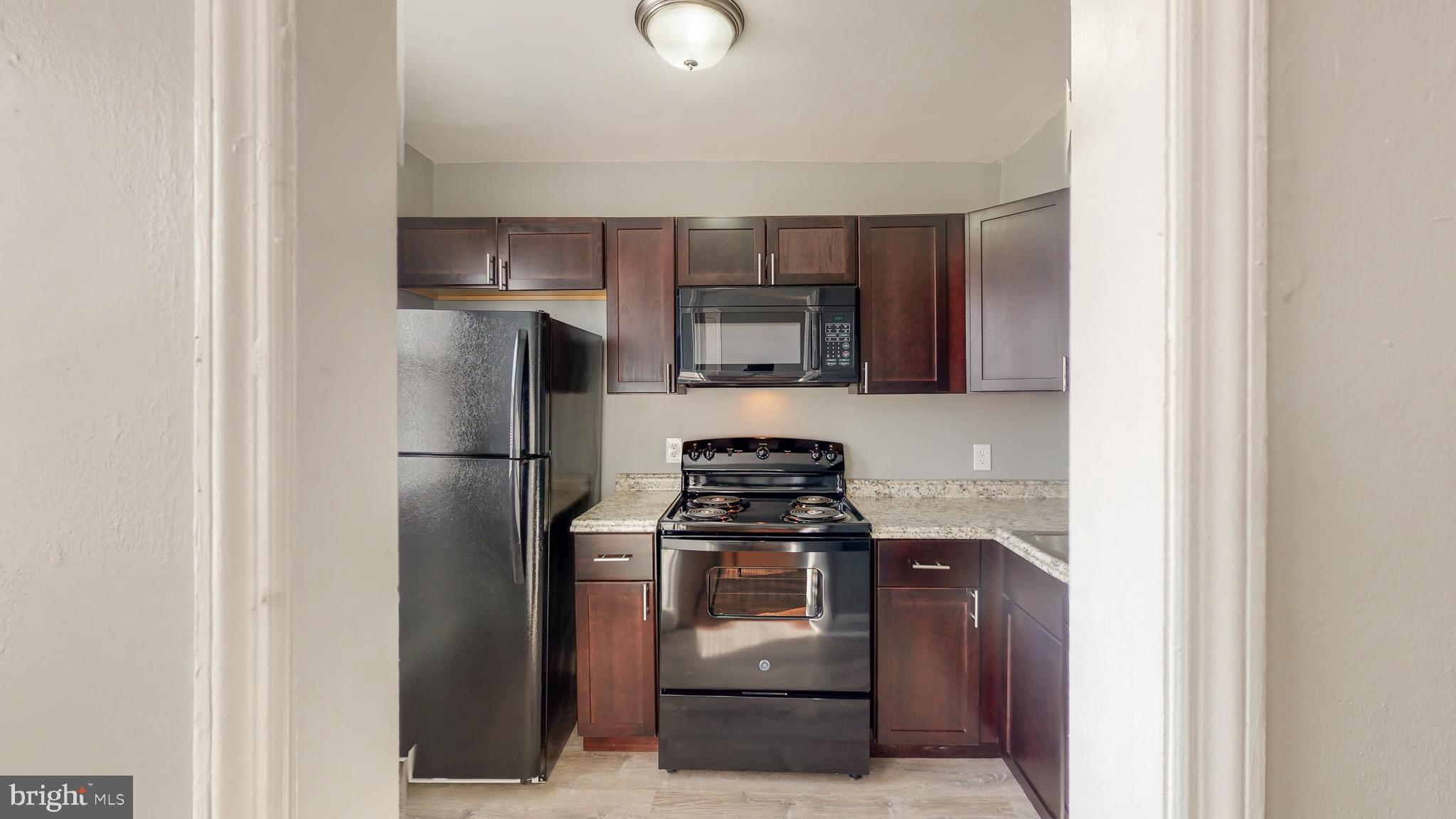 1102 Gleneagle Road Baltimore, MD 21239 - Photo 2 of 19 a kitchen with a refrigerator stove and microwave