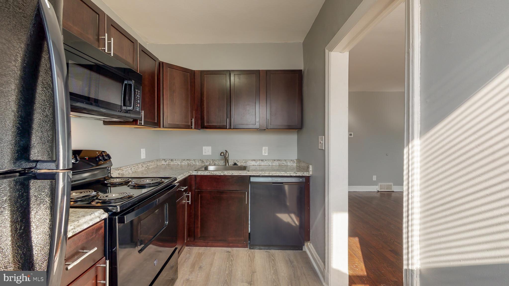 1102 Gleneagle Road Baltimore, MD 21239 - Photo 3 of 19 a kitchen with stainless steel appliances granite countertop a stove a sink and a microwave