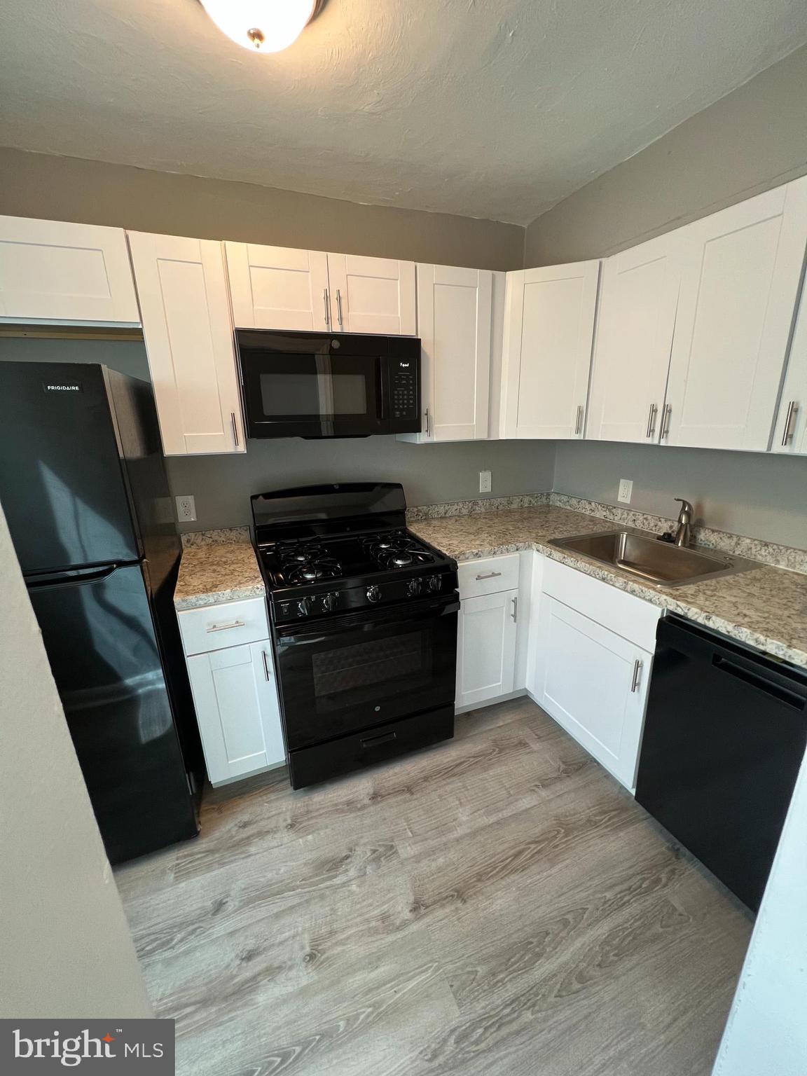 1102 Gleneagle Road Baltimore, MD 21239 - Photo 7 of 19 a kitchen with a sink a stove top oven a counter space and cabinets