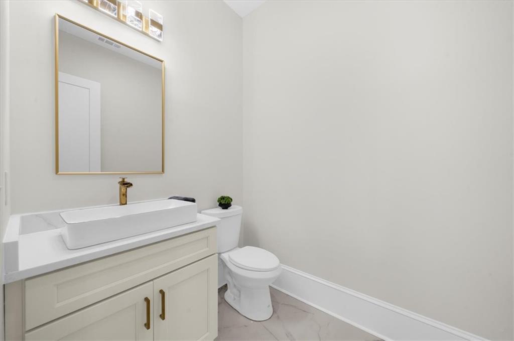 4543 Fawn Path Gainesville, GA 30506 - Photo 44 of 96 a bathroom with a toilet a sink and mirror