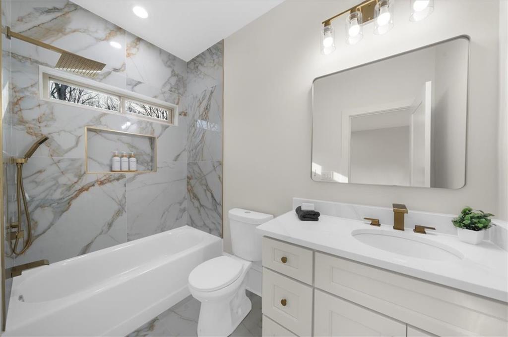 4543 Fawn Path Gainesville, GA 30506 - Photo 75 of 96 a bathroom with a bathtub shower sink vanity mirror and toilet