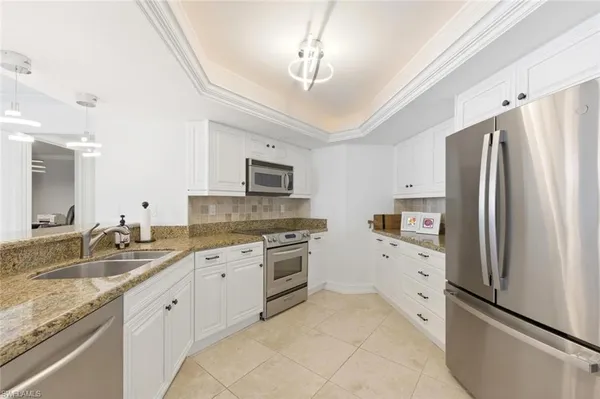 a kitchen with granite countertop cabinets stainless steel appliances a sink and a counter top space
