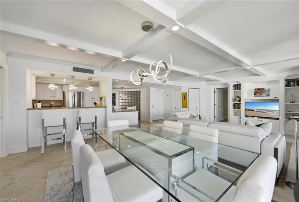 a living room with furniture kitchen view and a chandelier