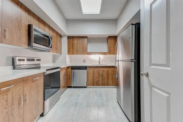 a kitchen with stainless steel appliances granite countertop a stove a sink and a microwave