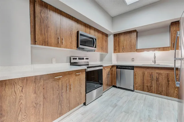 a kitchen with a sink a cabinets and window stainless steel appliances