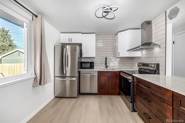 a kitchen with stainless steel appliances a refrigerator sink and stove