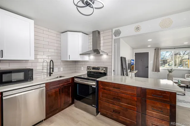 a kitchen with kitchen island granite countertop a sink and stove top oven