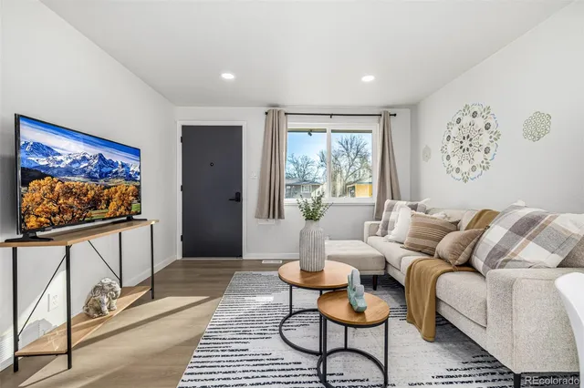 a living room with furniture a rug and a flat screen tv