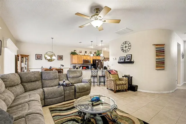 a living room with furniture kitchen view and a window