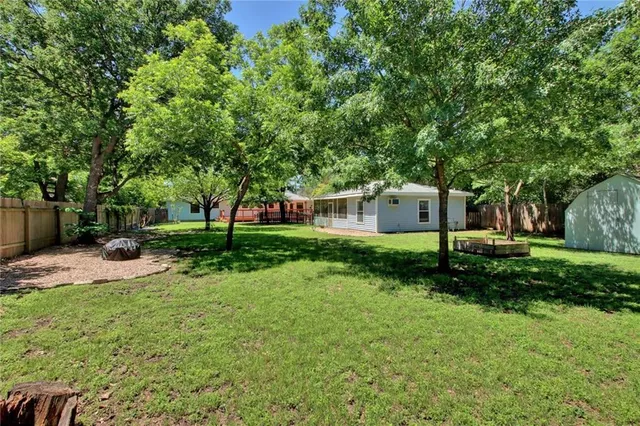 a view of a house with backyard and trees