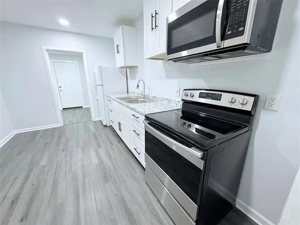 a kitchen with stainless steel appliances a stove microwave and sink